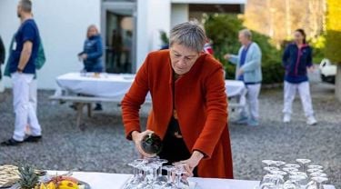 Dame som sjenker i glass. 