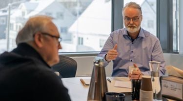 To menn diskuterer over et bord
