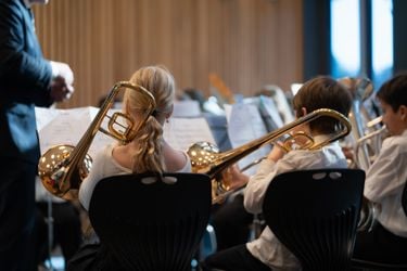 To som spiller trombone, sett bakfra. 