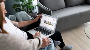To personer som sitter å ser på en PC